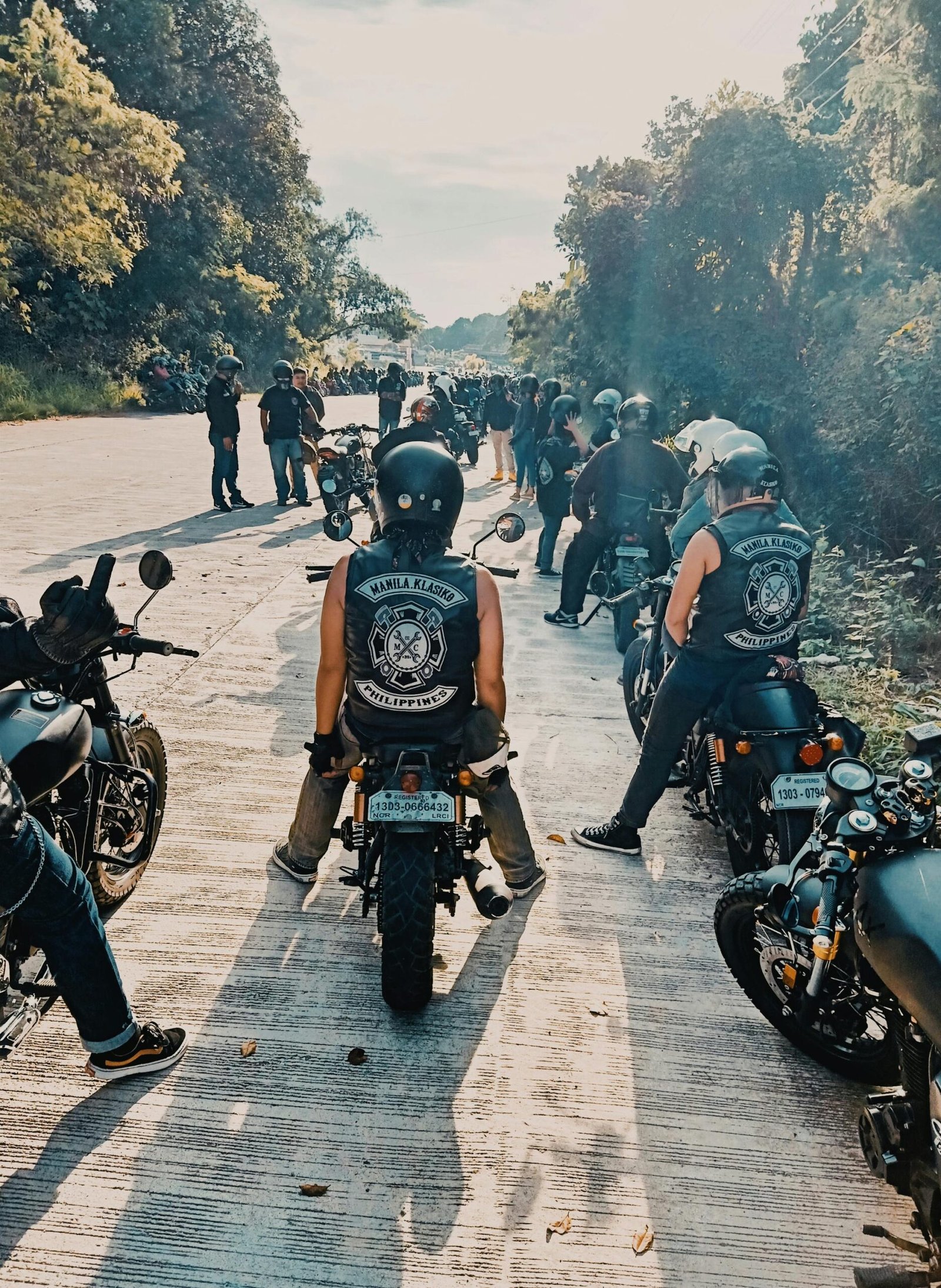 Motorcyclists gather on a sunny road for a group ride, showcasing camaraderie.